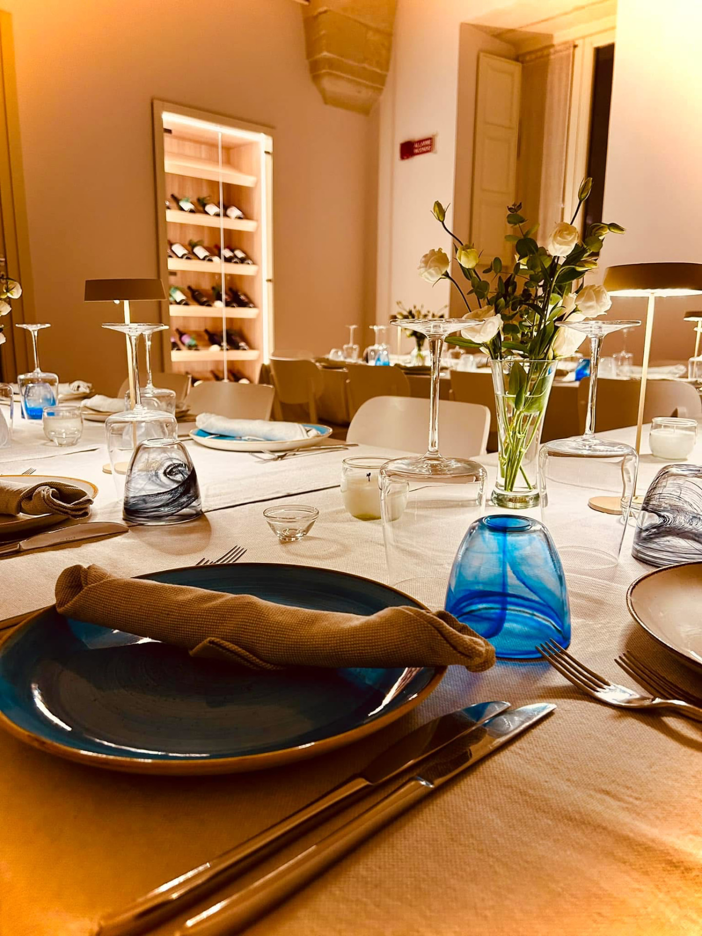 Sala con tavoli apparecchiati e cantina sullo sfondo